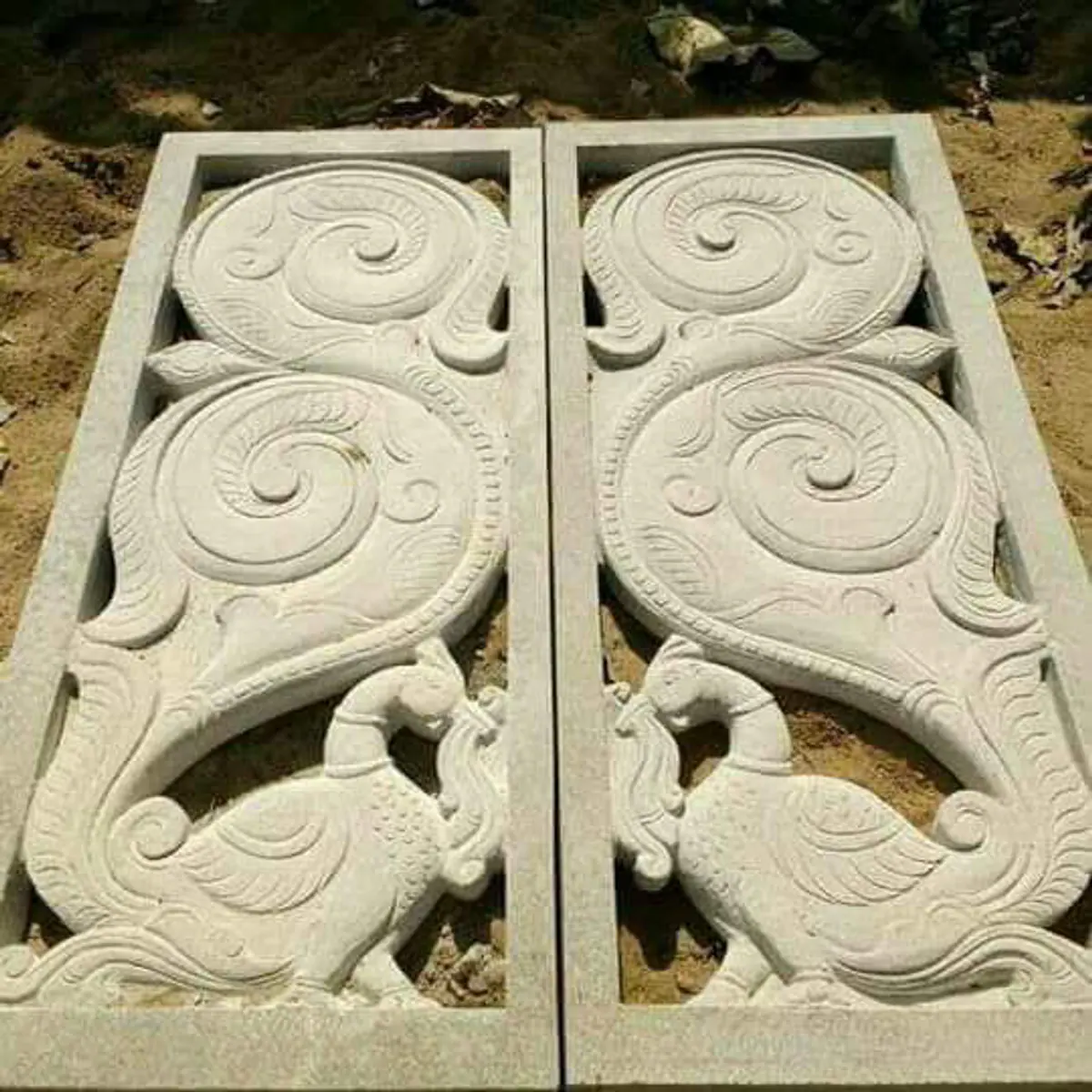 Paired stone panels with peacocks and floral scrollwork