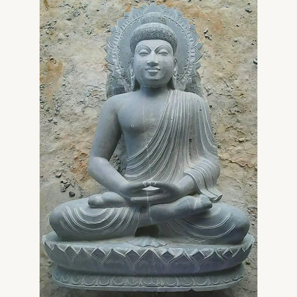 Seated Buddha statue with hands in the lap, a carved halo, and a lotus-patterned base